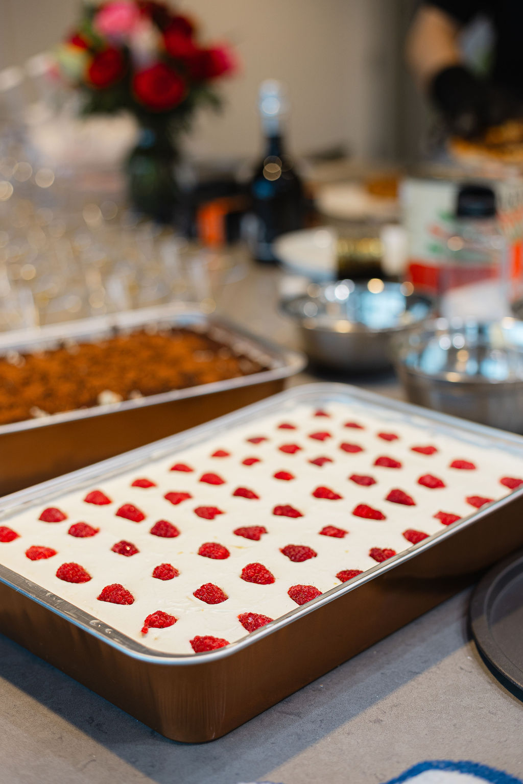 A raspberry-topped dessert made in class, with roses and sparkling wine in the background, at a bachelorette celebration at Stirring It Up in Calgary