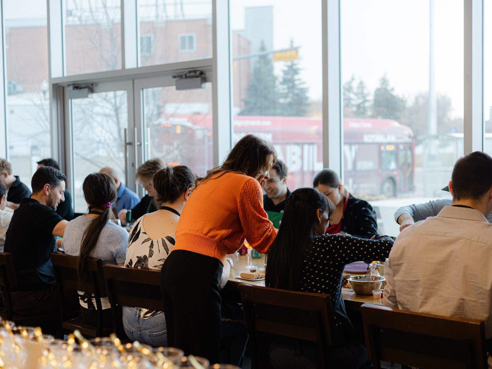 Guests cooking together at the long table during an evening class at Stirring It Up in Calgary
