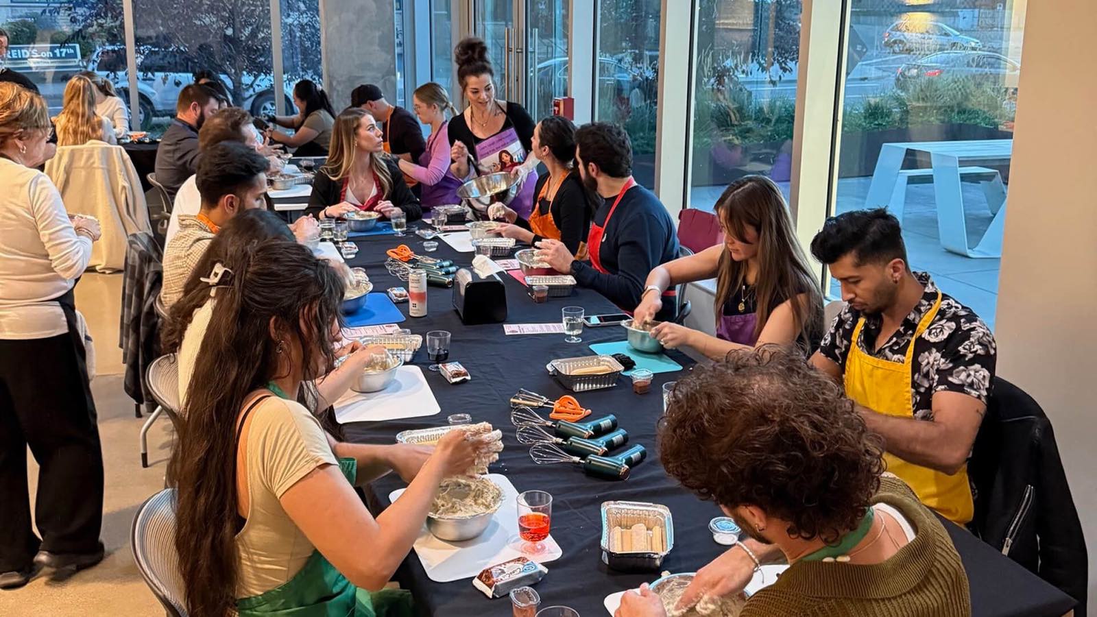 A full class working dough by hand down both sides of the long table at Stirring It Up in Calgary